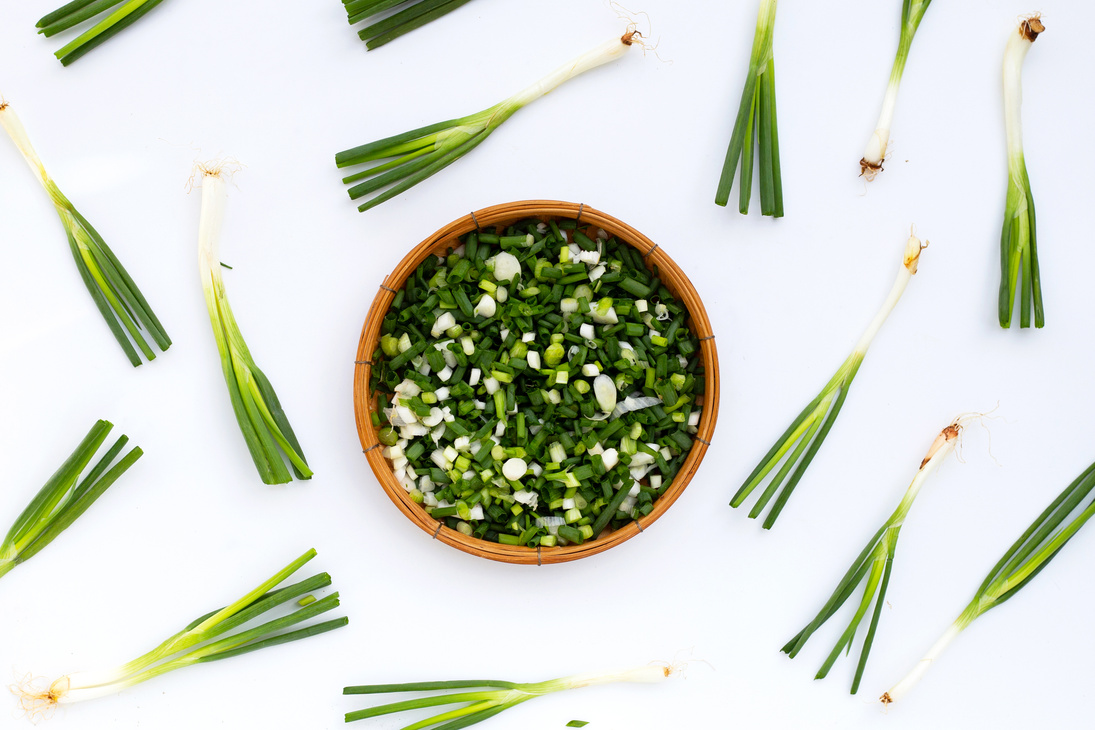 chopped spring onions on white background